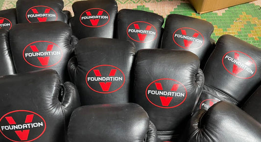 boxing gloves in black with red and white accents. 18oz optimal weight traiing, striking designs, comfortable fit, versatility, signature branding. Foundation V boxing gloves are a perfevt edition if you dcide to take boxing up or if you just do it partake at your favorite gym.